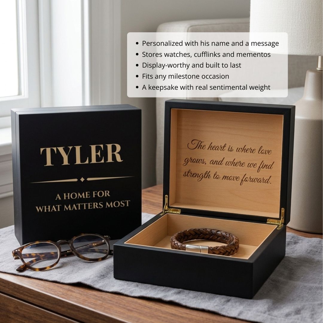 Black wooden keepsake box engraved with sample name "TYLER" and motivational quote on lid, shown open with cedar-lined interior and braided leather bracelet inside