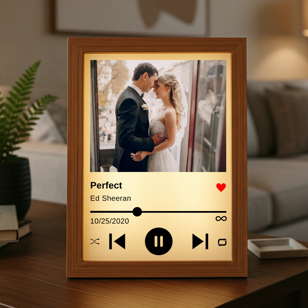 Decorative frame with a wedding photo and music player interface on a table.