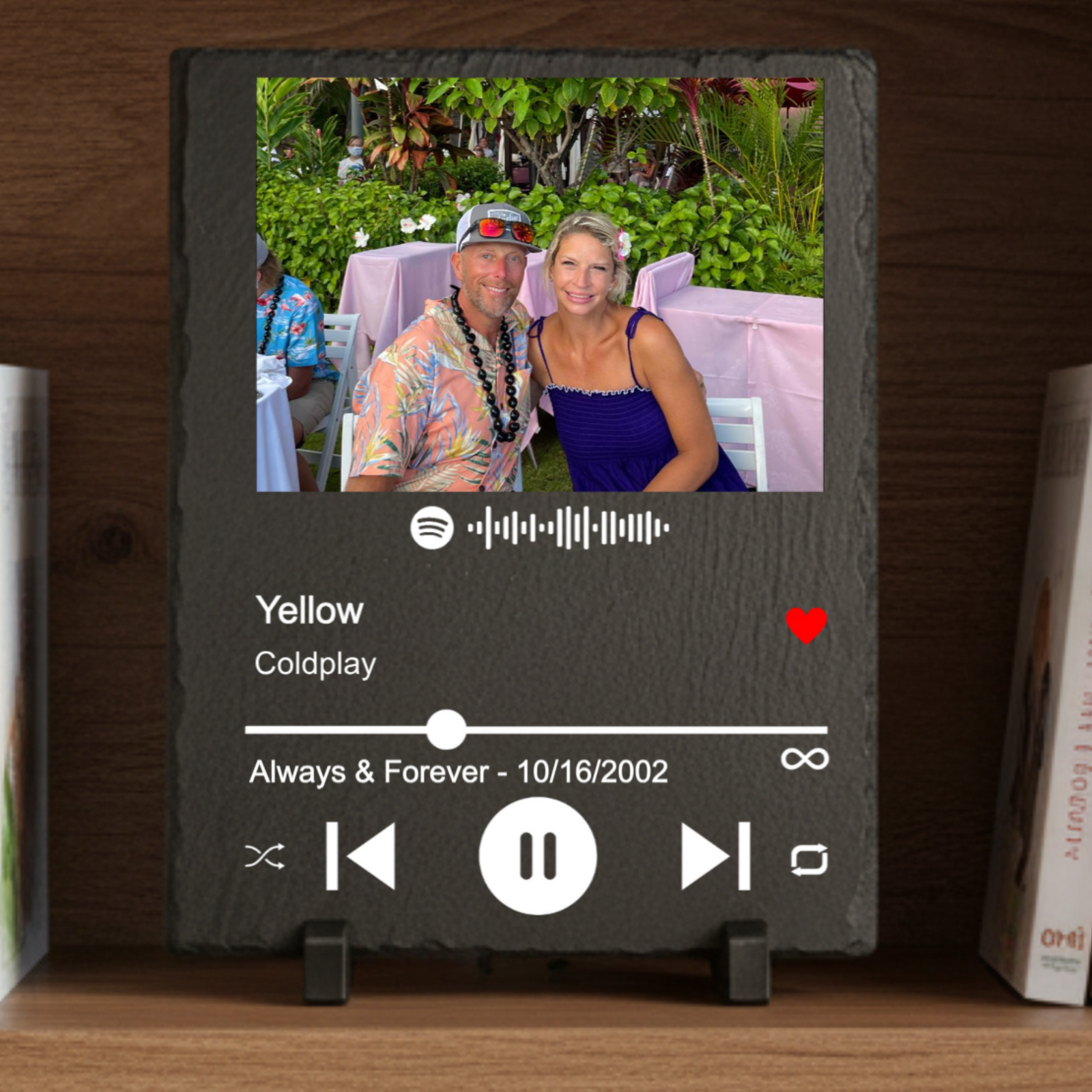 Dark slate plaque featuring a photo of a couple at an outdoor event, with Spotify player interface displaying "Yellow" by Coldplay and a custom date "Always & Forever - 10/16/2002