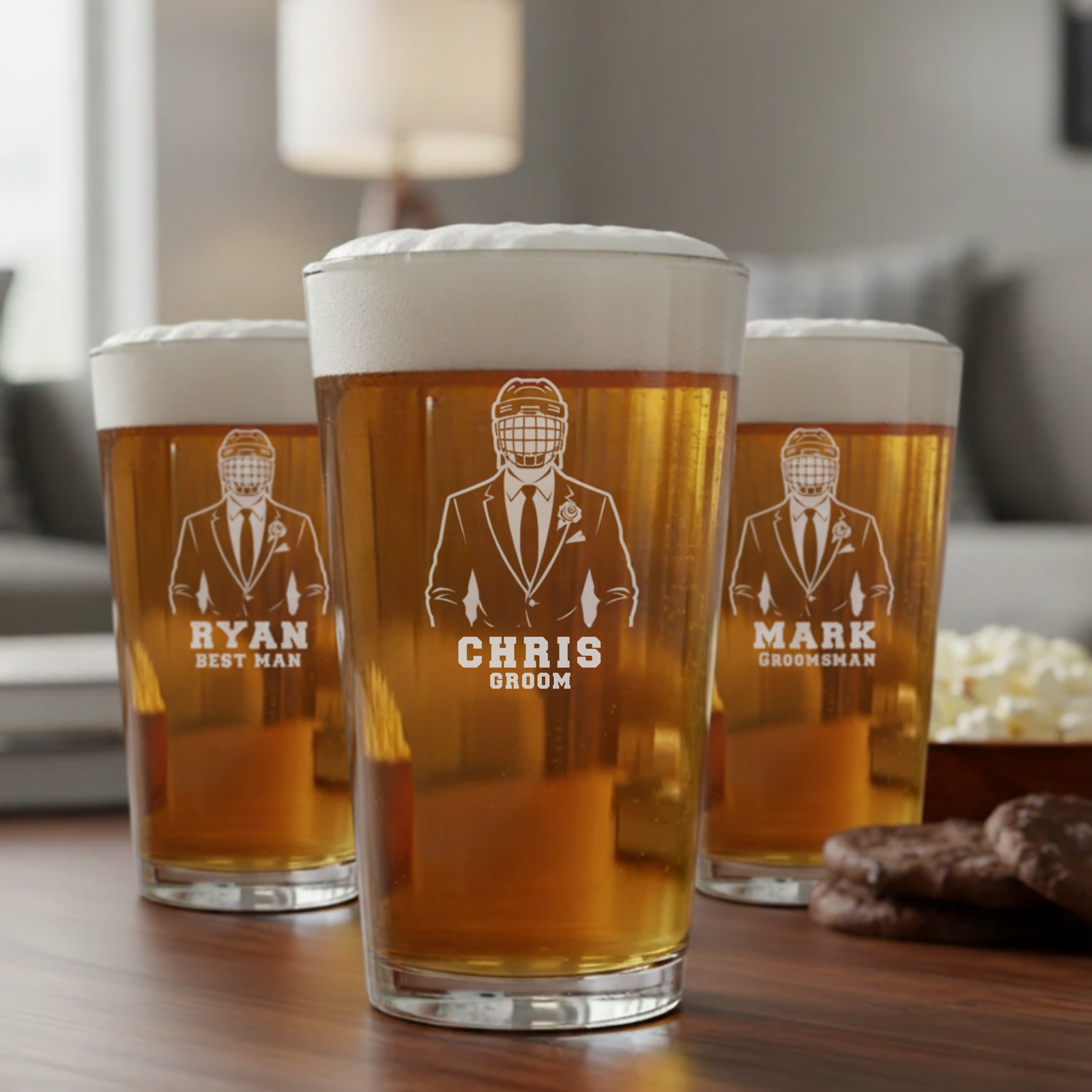 Three personalized pint glasses with laser-etched hockey player designs labeled "RYAN BEST MAN," "CHRIS GROOM," and "MARK GROOMSMAN," filled with beer and topped with foam.