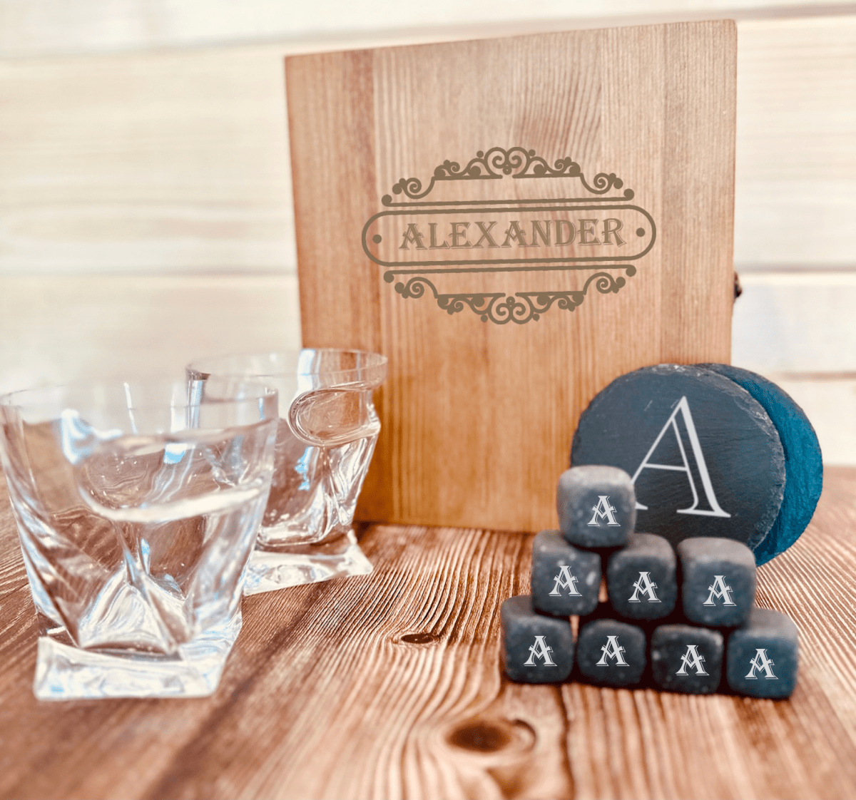 Personalized whiskey glass and stones set for groomsmen displayed with its natural slate coasters engraved with a single initial.