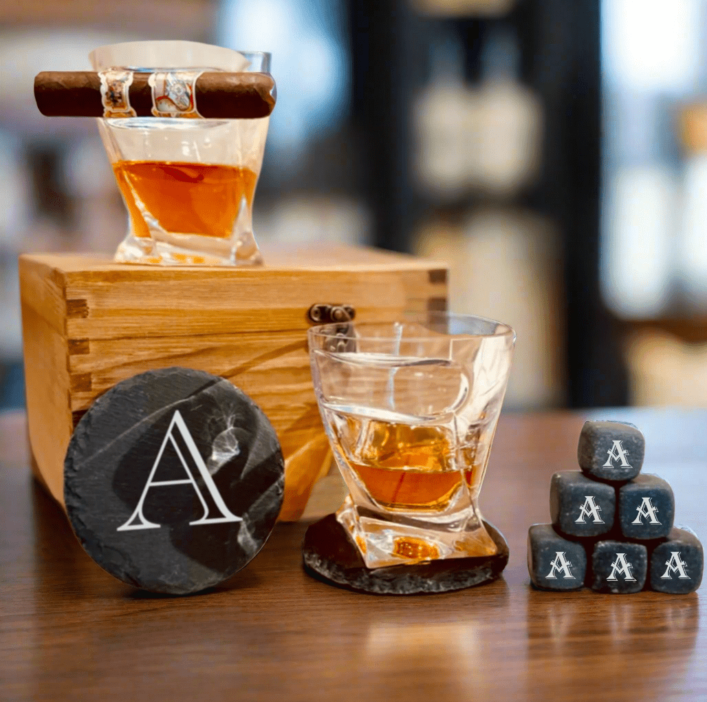 Detail view of the whiskey glass with cigar rest from the personalized groomsmen gift set, with whiskey stones chilling the pour.