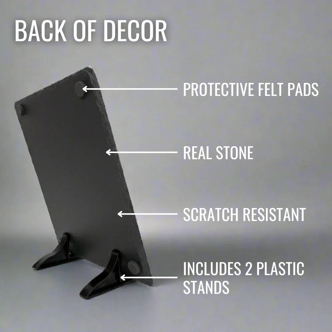 Back view of dark slate plaque showing protective felt pads at top corners, real stone surface, and two included black plastic easel stands for display