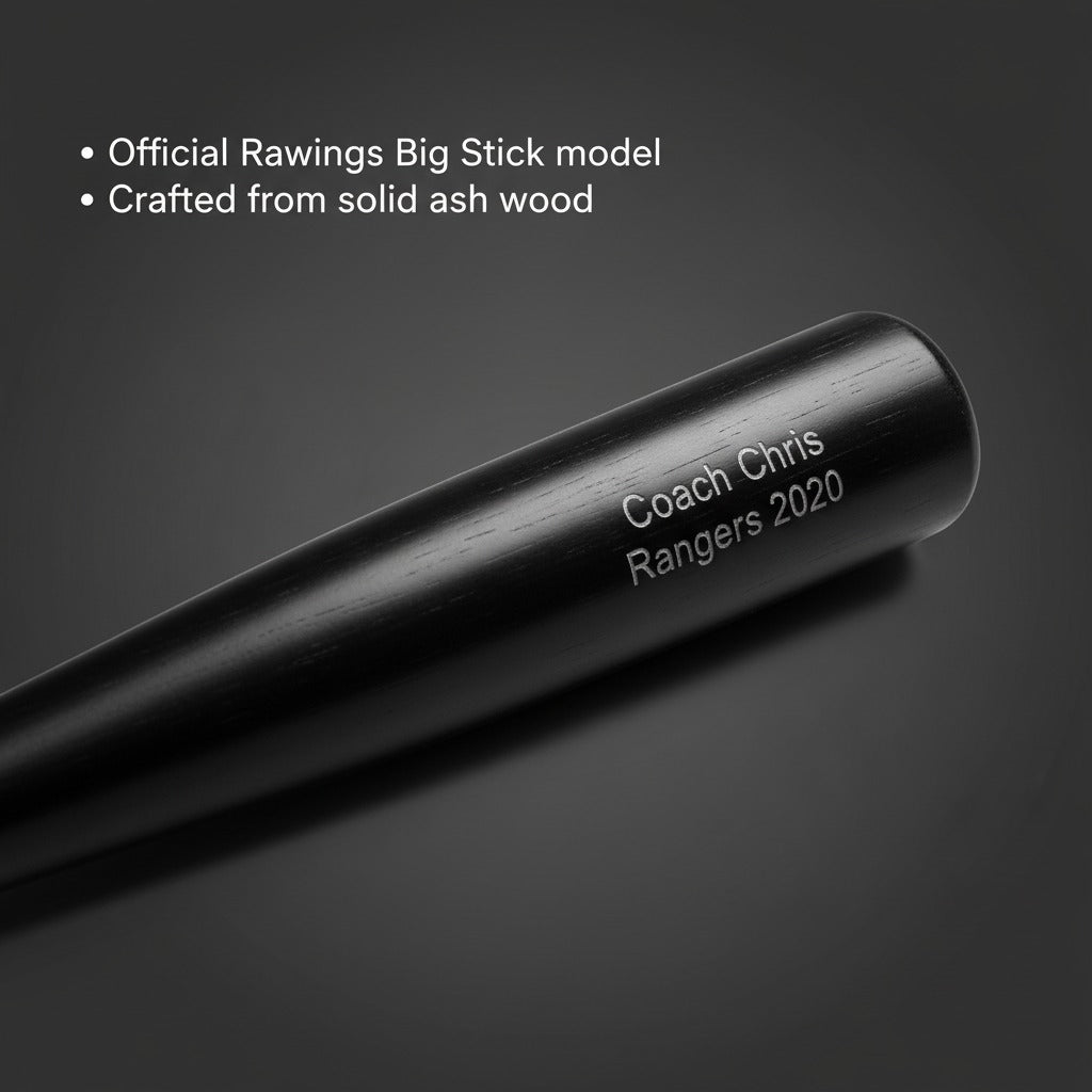 Black ash wood baseball bat engraved with sample text "Coach Chris Rangers 2020" showing personalization detail