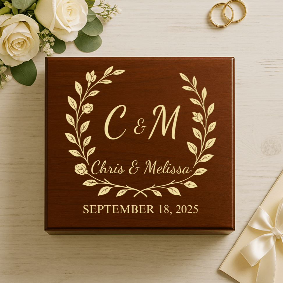 Dark walnut wooden keepsake box with gold leaf engraving showing sample monogram "C&M", full names "Chris & Melissa", and wedding date "September 18, 2025" surrounded by decorative floral wreath design