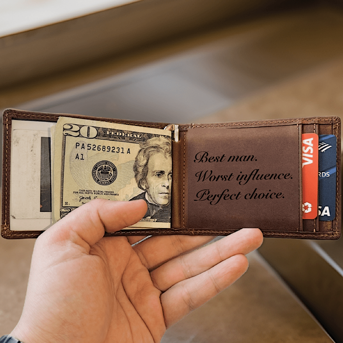 Personalized best man wallet held open, showing a message from the groom laser-engraved inside the brown leather panel.