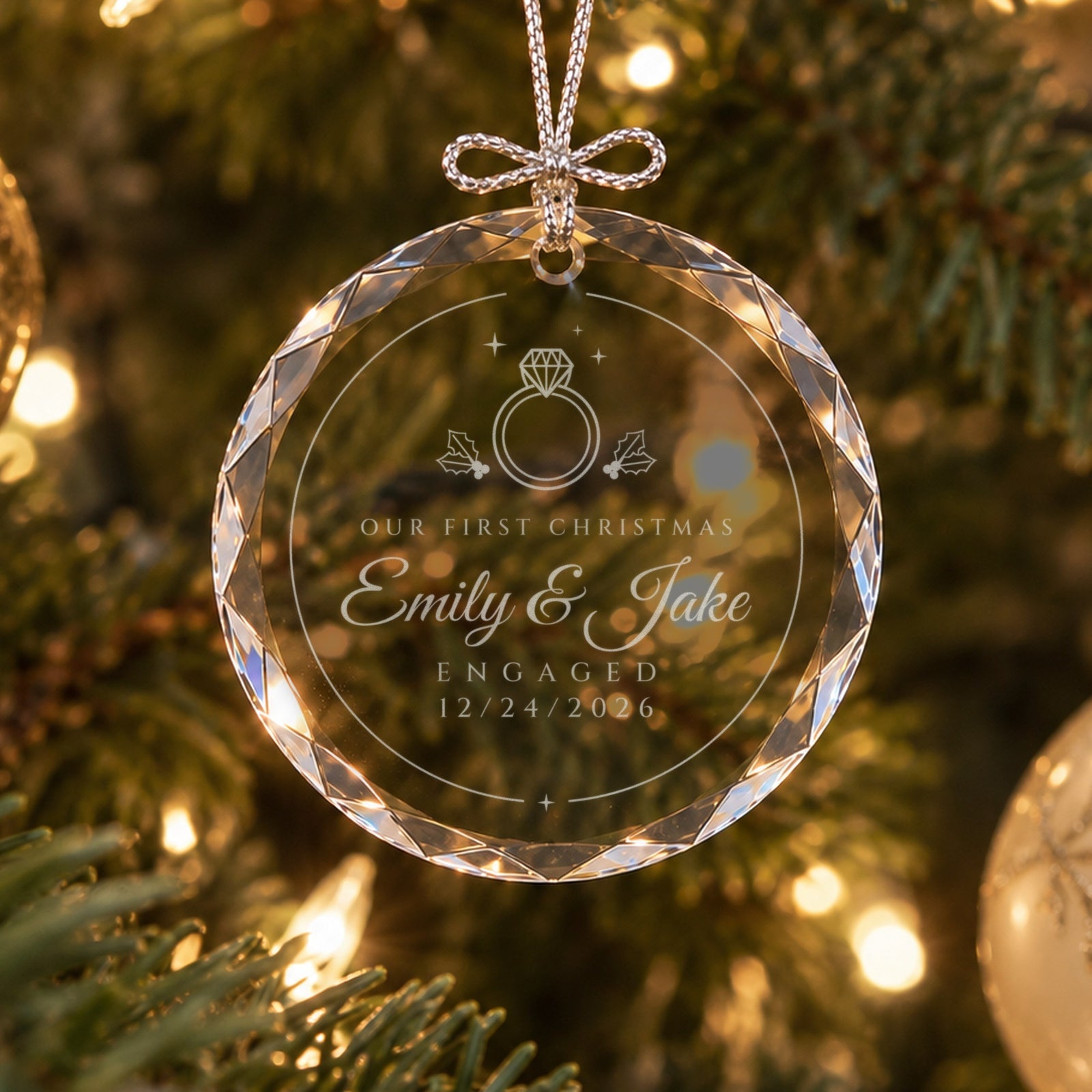 Personalized first Christmas engaged ornament in faceted glass on a lit Christmas tree, engraved with a ring, holly, Emily & Jake and ENGAGED 12/24/2026