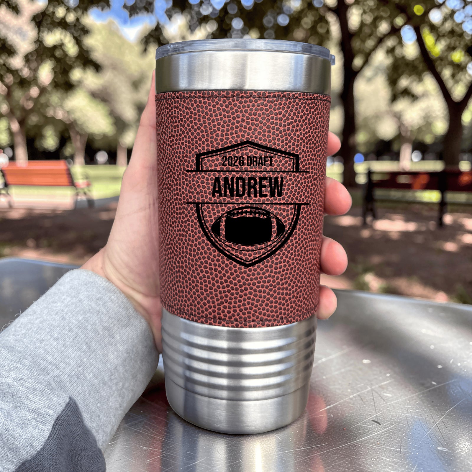 Stainless steel insulated tumbler with red football texture grip, personalized with sample engraving "2026 DRAFT ANDREW" and shield emblem design