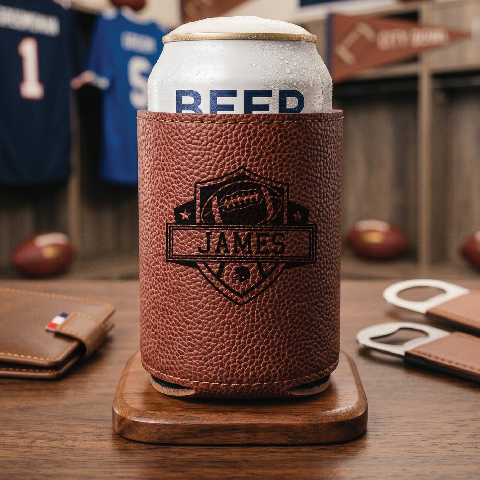 Football grain can cooler from the groomsmen draft proposal set holding a chilled can, engraved with a football shield and the personalized name James.