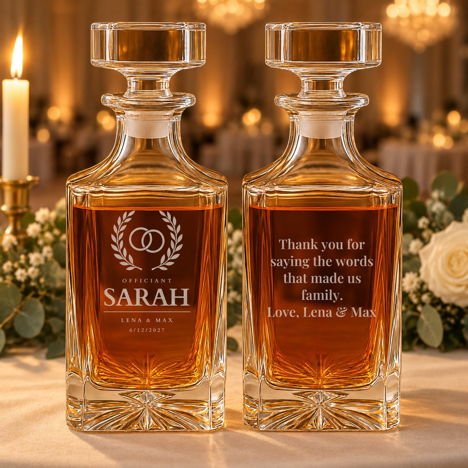 Officiant gift on a sweetheart table at a wedding reception: two whiskey decanters, one engraved Sarah, the other back engraved with a thank-you from Lena and Max