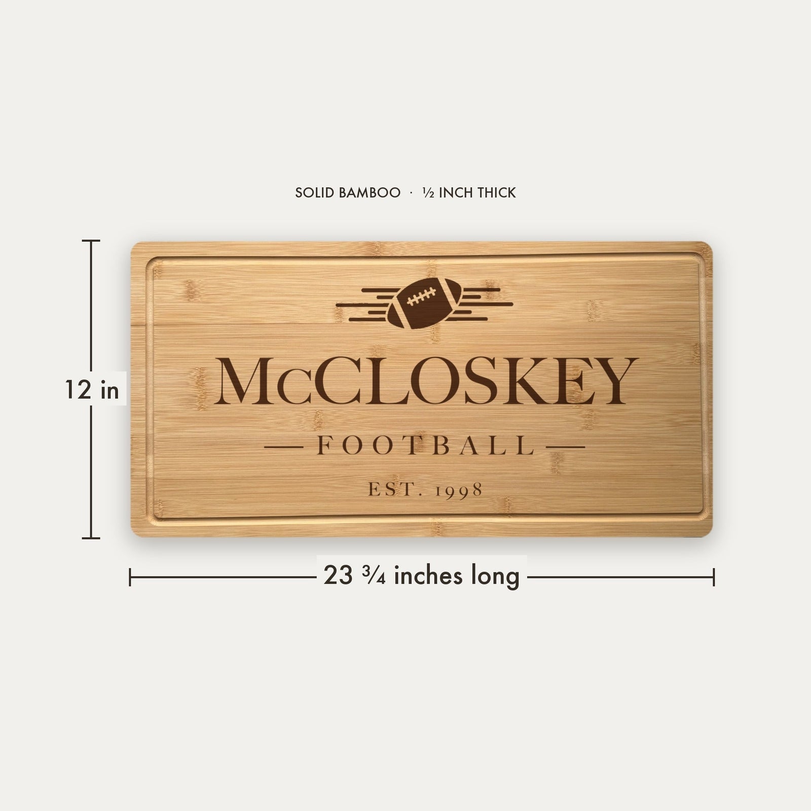 Size guide for the personalized football tailgate cutting board, 23 and three quarter inches long by 12 inches wide in half inch thick solid bamboo.