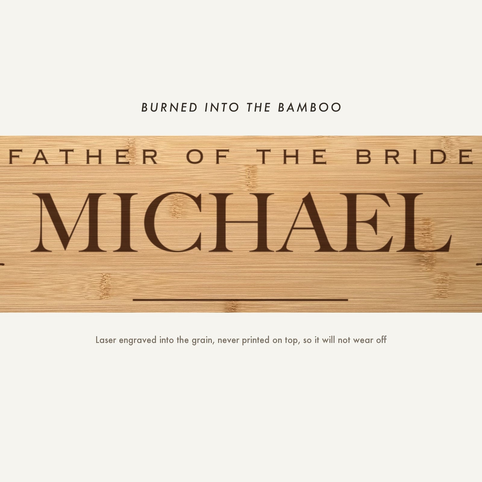 Close view of Father of the Bride and the name Michael laser engraved into the bamboo grain in spaced capitals above a fine horizontal rule.