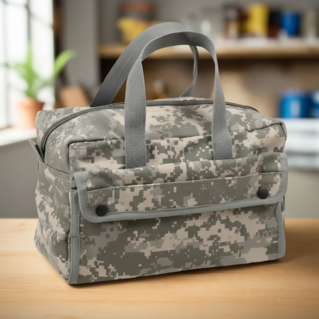 Digital camouflage canvas tool tote with gray handles and front snap-closure pocket, displayed on wooden surface