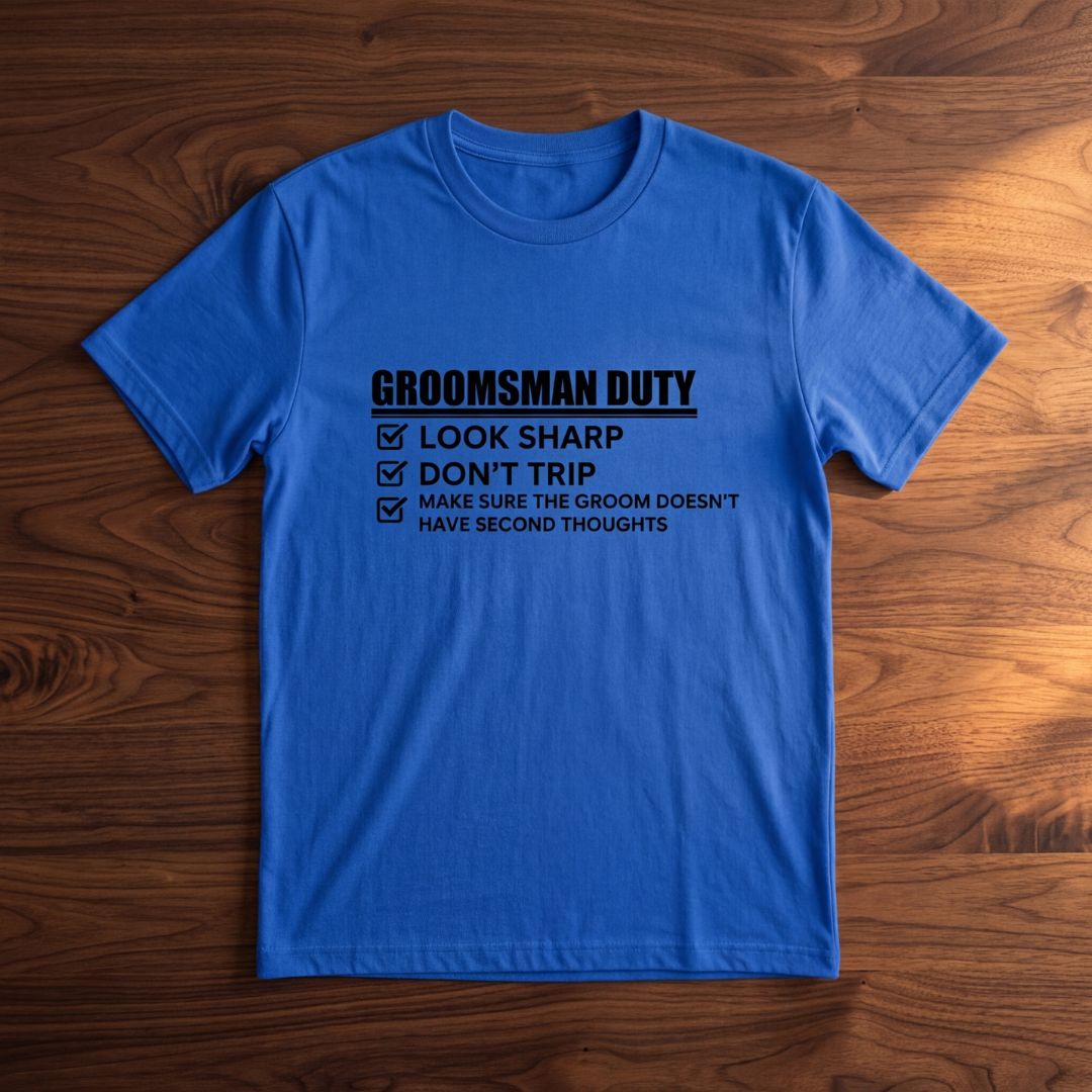 Royal blue t-shirt printed with "Groomsman Duty" checklist including look sharp, don't trip, and make sure the groom doesn't have second thoughts text with checkboxes.