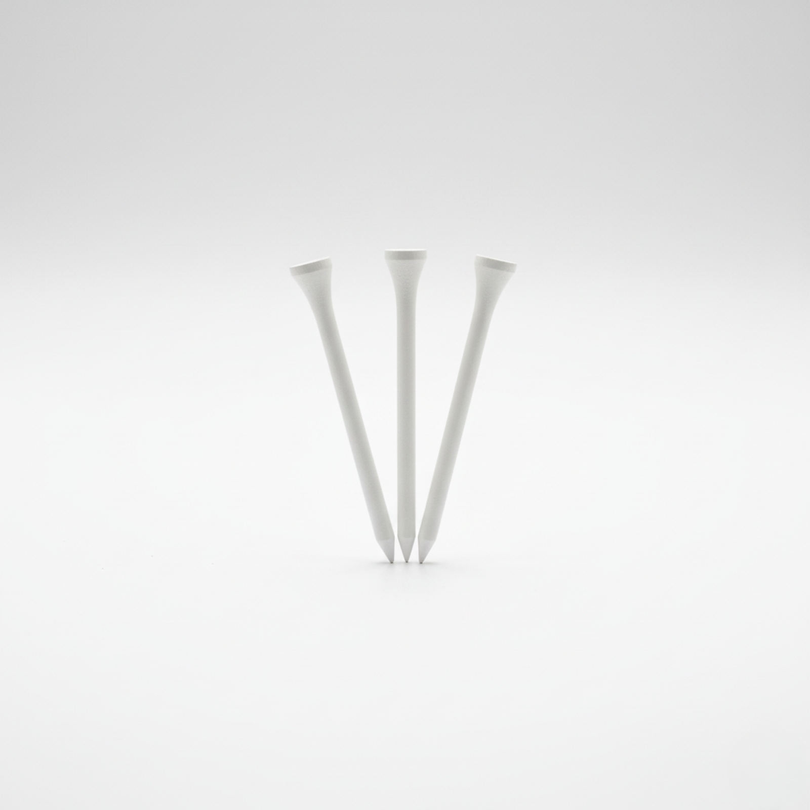 Three white golf tees arranged upright in a minimalist display against a neutral background