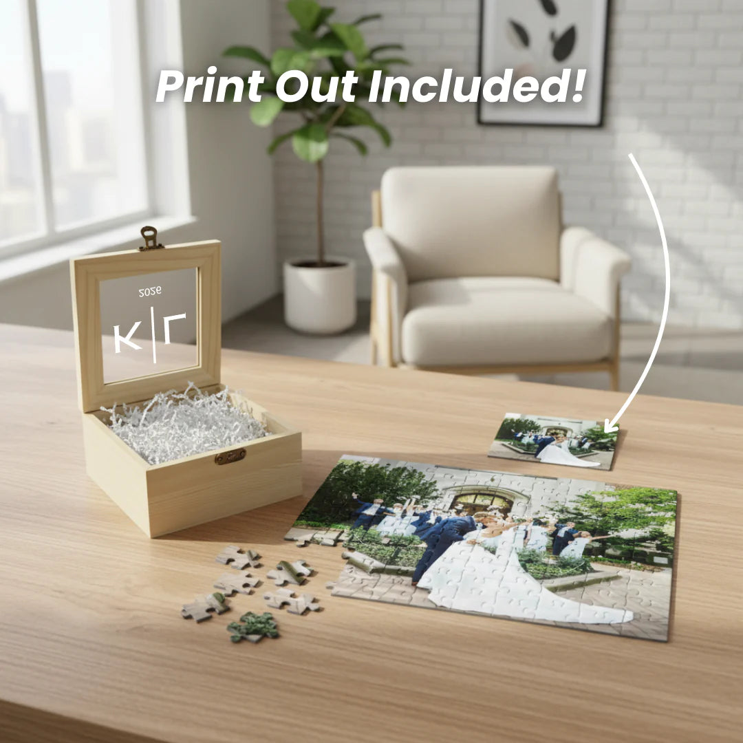 Wooden keepsake box with personalized window displaying sample initials and date, filled with shredded packaging material, shown alongside assembled custom photo puzzle pieces on wooden surface