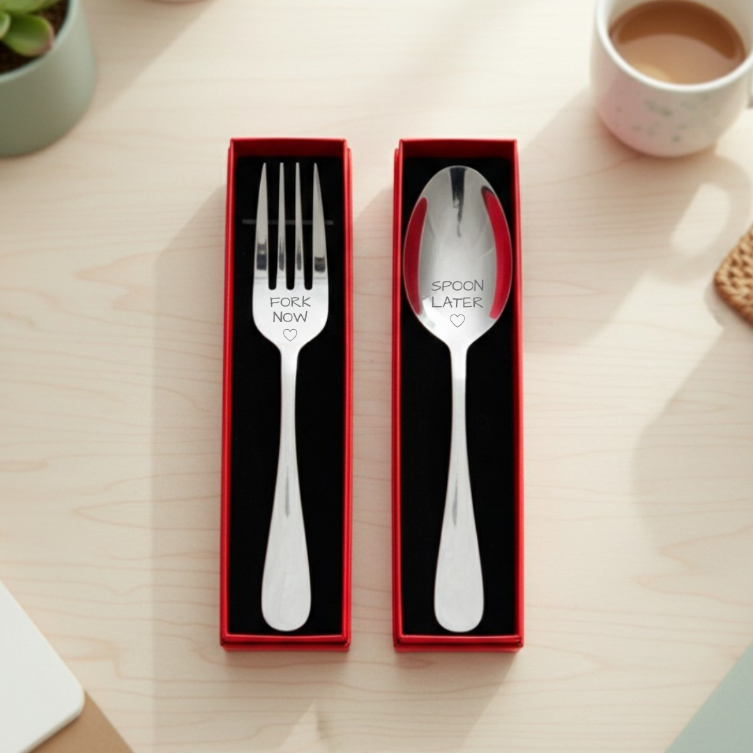 Stainless steel fork and spoon set in red gift box, engraved with "Fork Now" and "Spoon Later" text with heart motifs, displayed on wooden surface