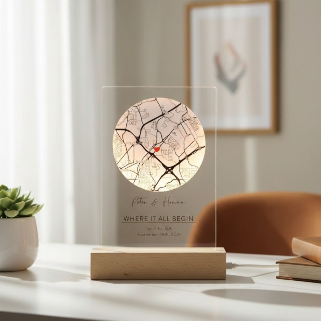 Frosted glass romantic map sign with personalized names "Peter &amp; Hanna," location "Tan-Cha, GA," date "September 26th, 2021," and red marker pin on circular map, mounted on wooden base.