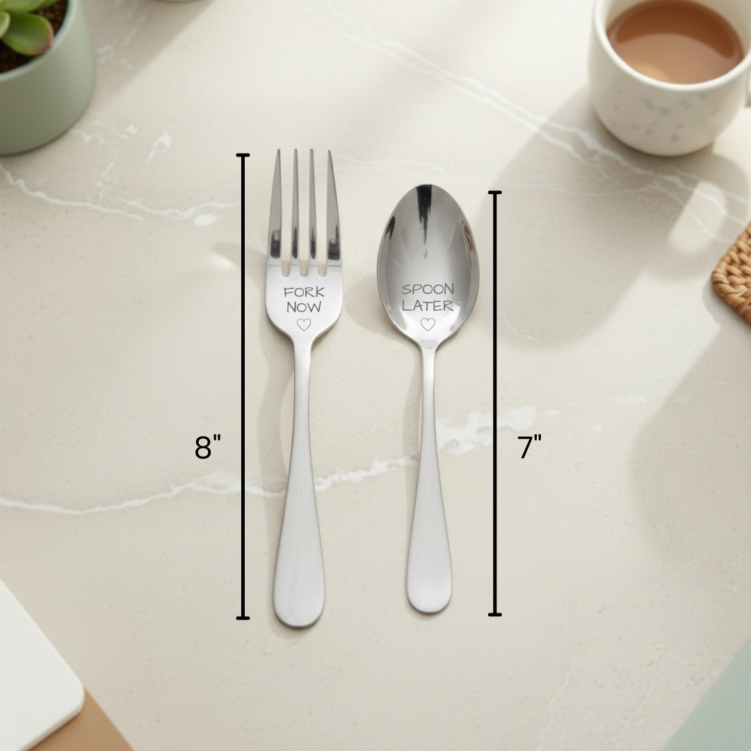 Stainless steel fork engraved "Fork Now" and spoon engraved "Spoon Later" with size measurements displayed on marble surface