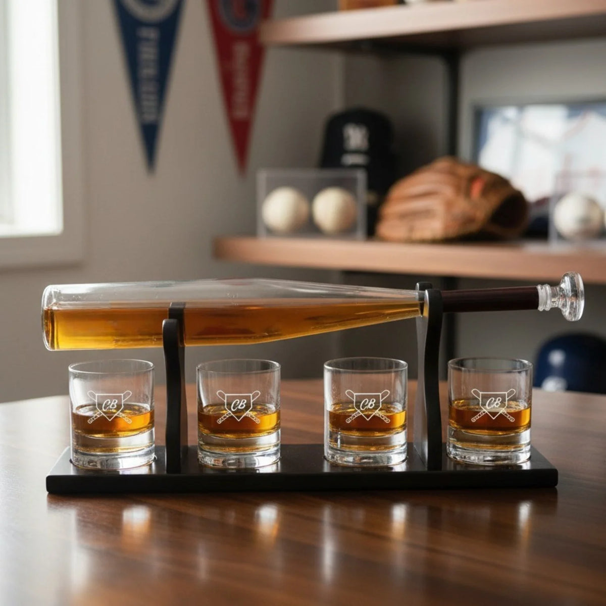 Baseball bat-shaped decanter filled with amber whiskey, tilted on mahogany stand above four whiskey glasses engraved with sample initials "CB" and crossed-bat design