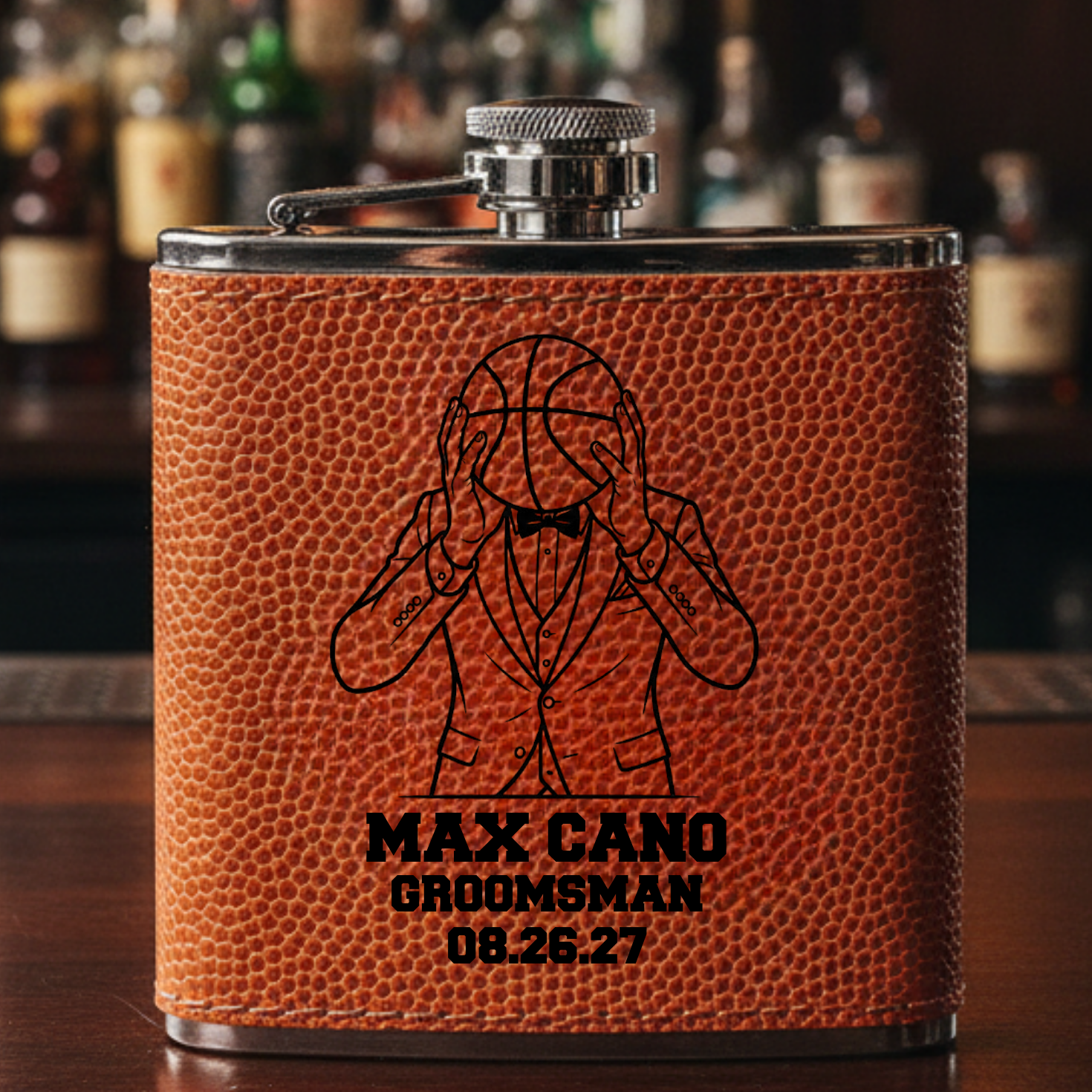 Basketball-textured leather flask with laser-engraved sample design featuring suited player holding basketball and custom text "MAX CANO GROOMSMAN 08.26.27