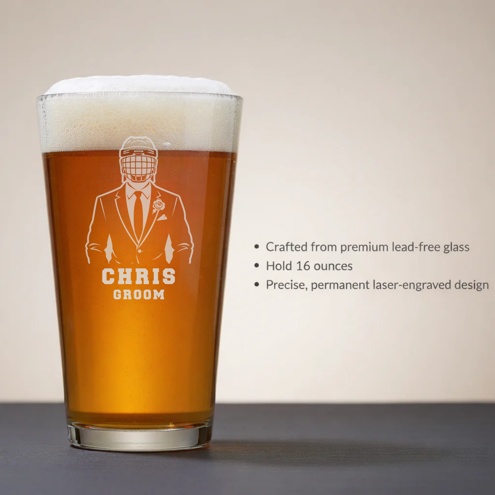 16-ounce pint glass filled with amber beer, laser-engraved with sample personalization reading "CHRIS" and "GROOM" beneath an illustration of a suited figure wearing a hockey helmet
