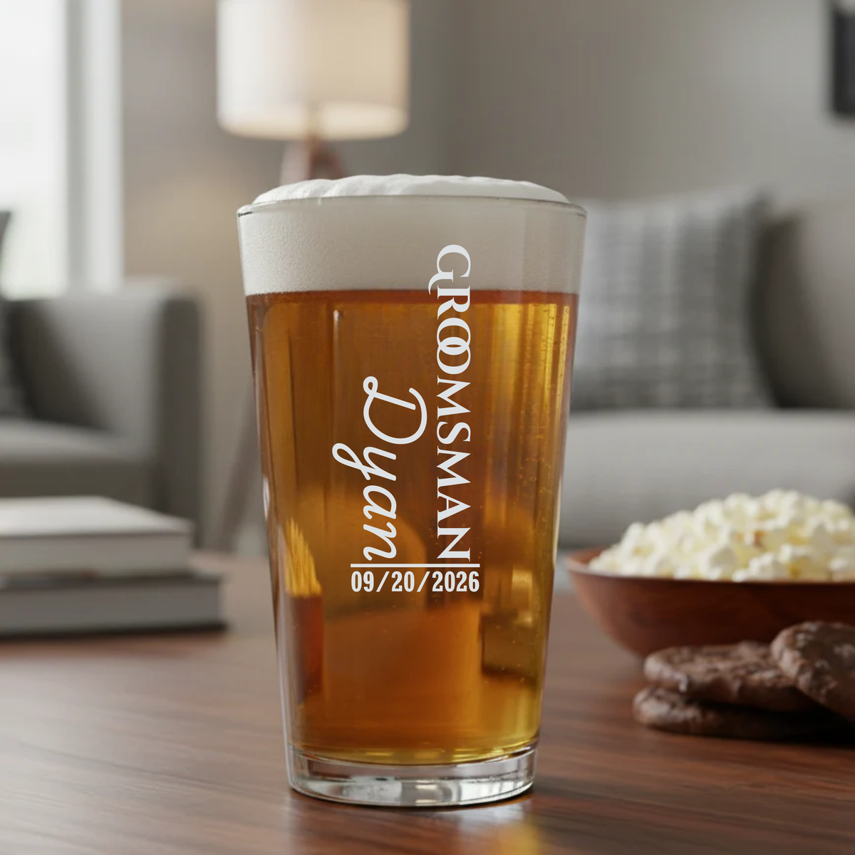 Pint glass filled with amber beer, engraved with sample text "Grooms Crew" and "Dylan Groomsman" with date "09/20/2026" in white lettering