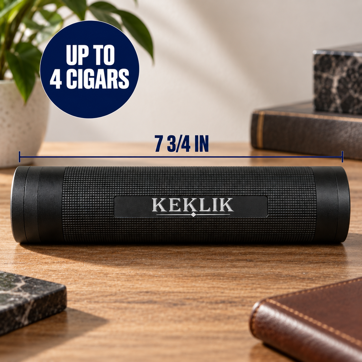 A black cylindrical KEKLIK portable speaker sits on a wooden tabletop, with a blue circular badge reading 'UP TO 4 CIGARS' and a dimension line indicating '7 3/4 IN' width. The scene includes a plant, books, and leather accessories in a styled indoor setting.
