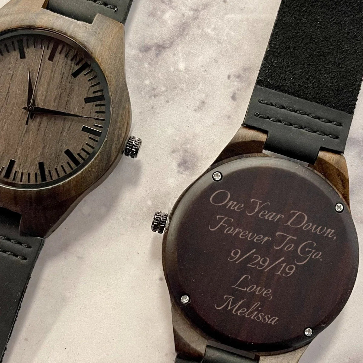 Wooden watch with engraved father in law message on a textured surface