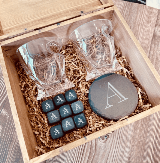 Personalized whiskey glass and stones groomsmen gift set shown with the engraved slate coasters and whiskey stones laid out beside the glass.