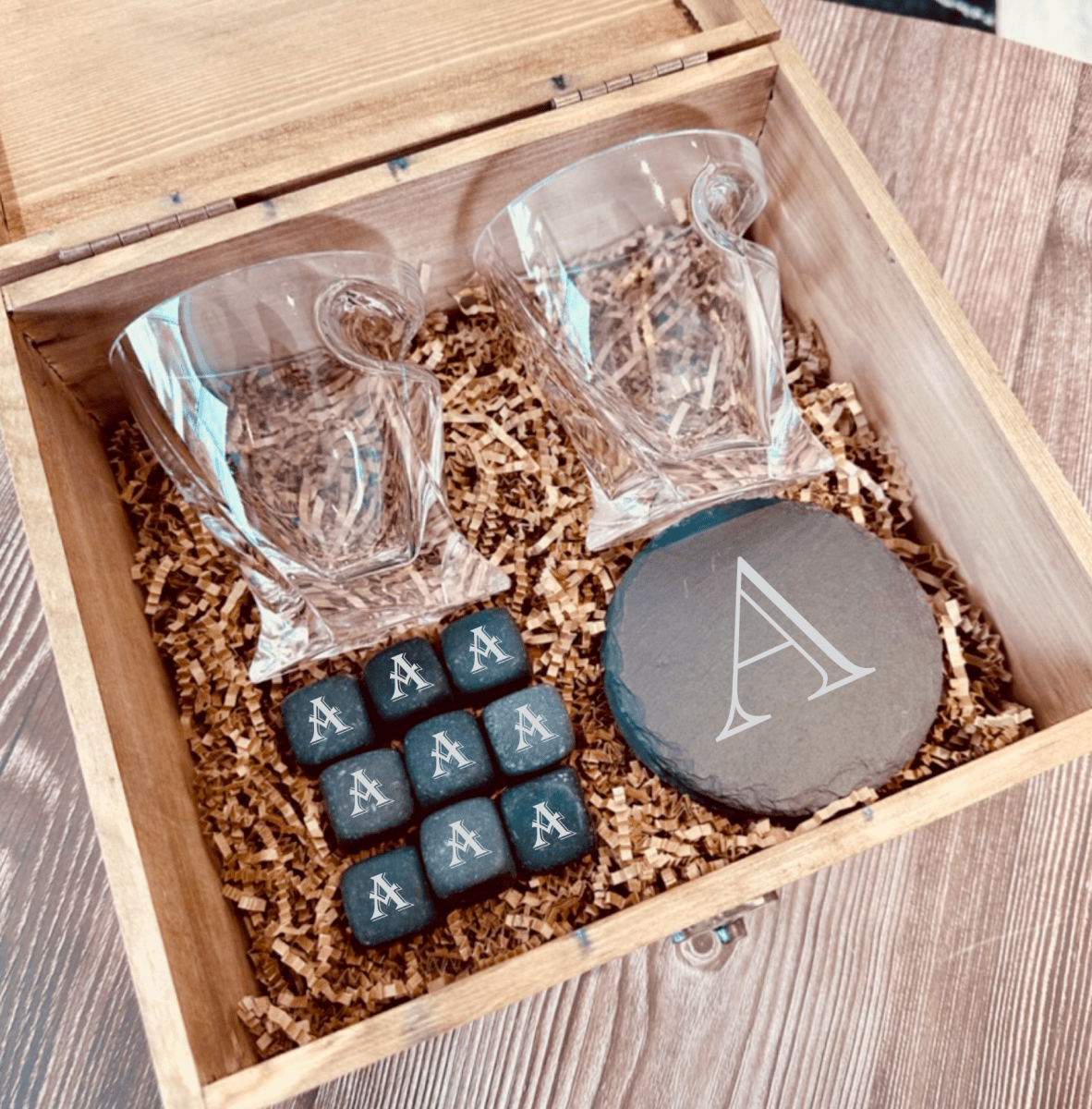 Personalized whiskey glass and stones groomsmen gift set shown with the engraved slate coasters and whiskey stones laid out beside the glass.