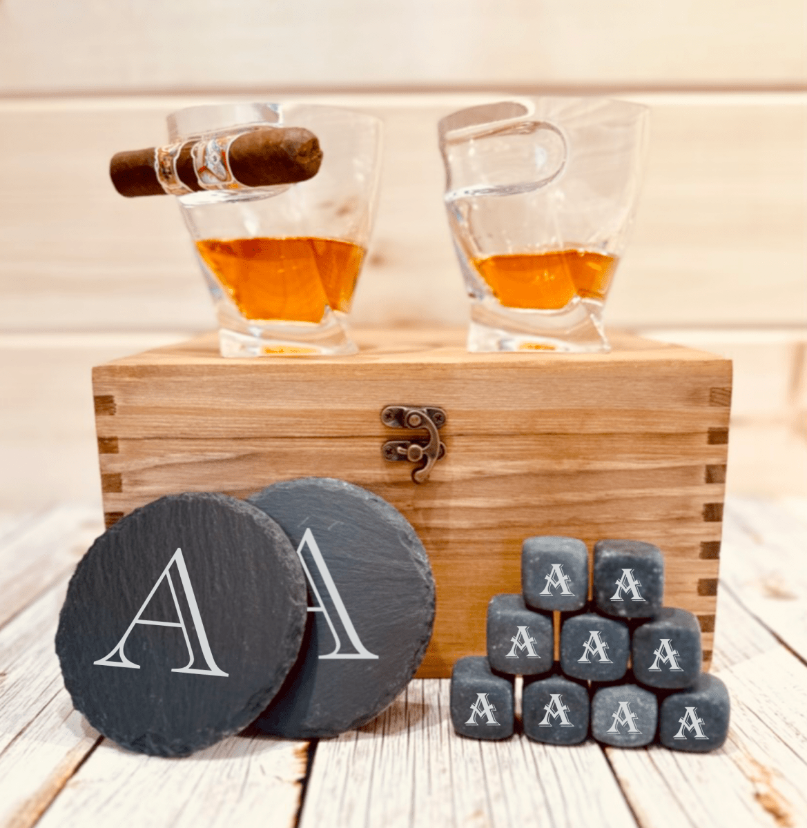 Whiskey stones and engraved slate coasters from the personalized groomsmen whiskey gift set arranged for a close look at the engraving.
