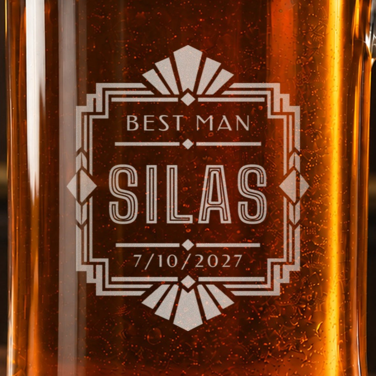 Close-up of the frosted Art Deco engraving on a groomsmen stein: a sunburst frame with diamonds, Best Man, the name Silas and the date 7/10/2027