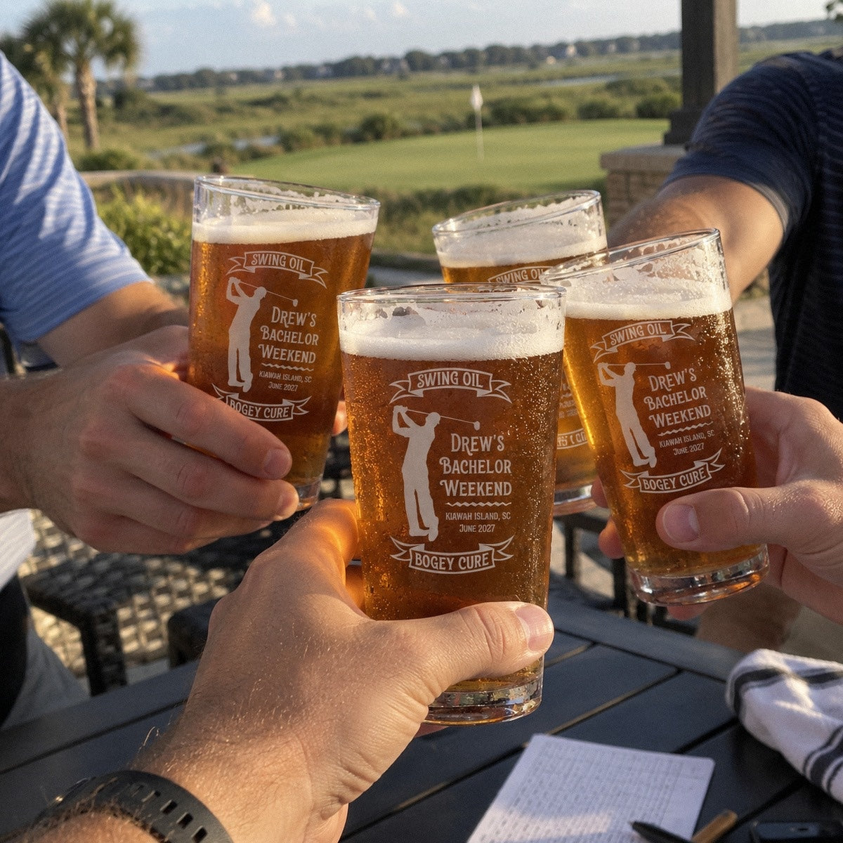 Bachelor party golfers toast with personalized golf swing oil pint glasses on a clubhouse patio after the round, a scorecard on the table