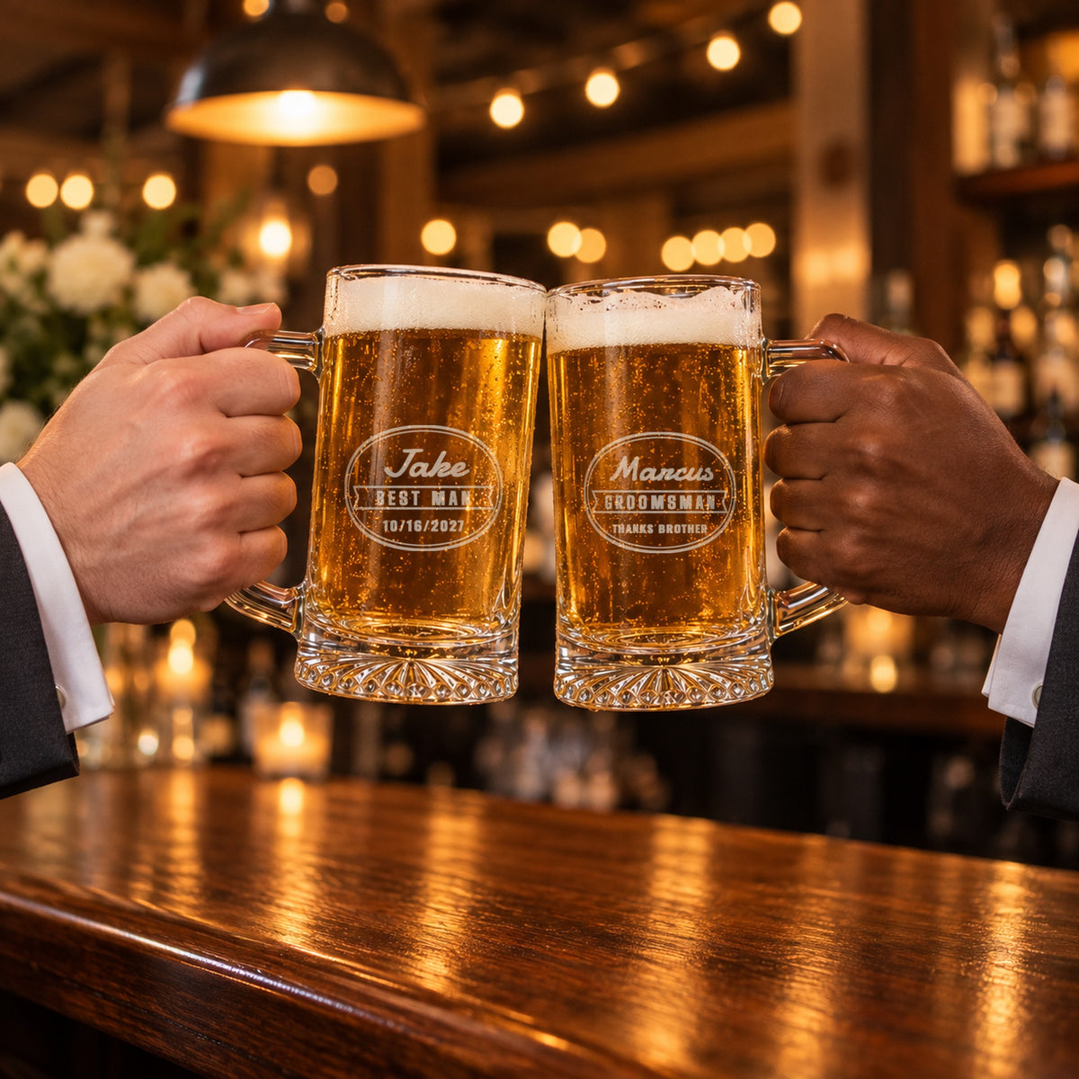 Two groomsmen toasting with engraved beer mugs, one etched Jake, Best Man, 10/16/2027 and one Marcus, Groomsman, Thanks Brother