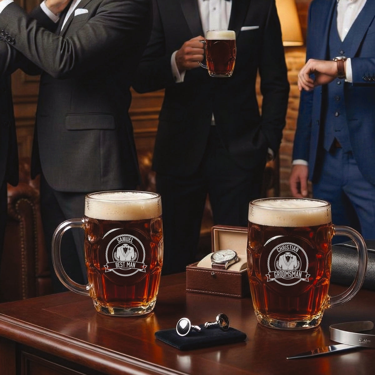 Two personalized beer mugs engraved with sample names "Samuel" and "Christy" and roles "Best Man" and "Groomsman," filled with beer and displayed on wooden table with men in formal suits in background.