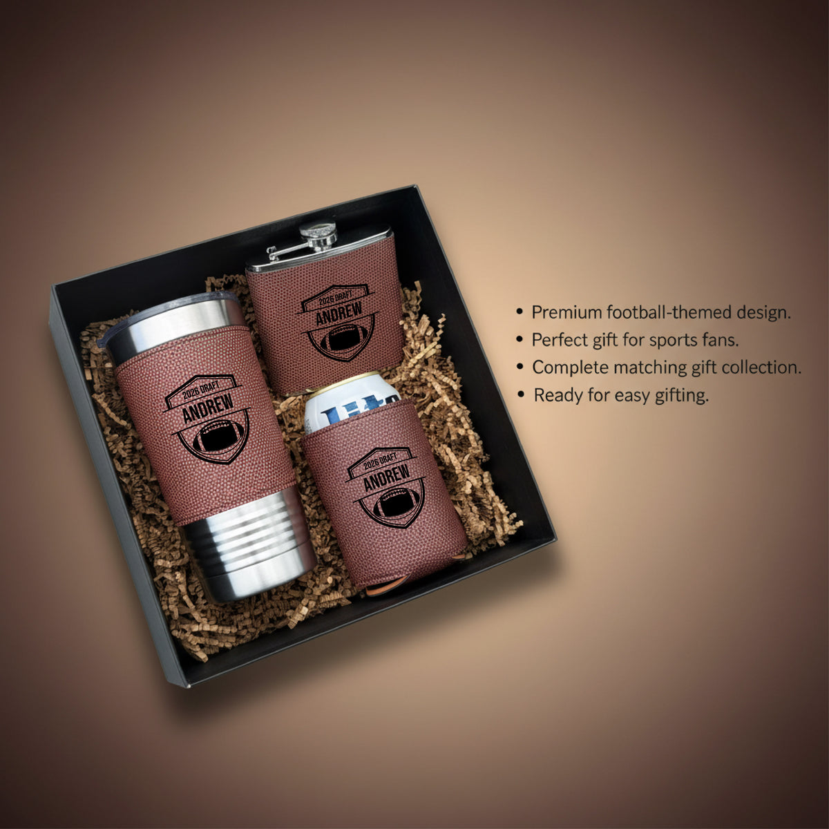 Black gift box containing personalized football-textured tumbler, flask, and koozies with sample name "ANDREW" and draft pick design, nestled in gold shredded packaging.