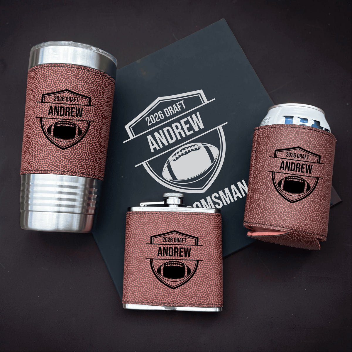 Three-piece gift set with personalized tumbler, koozies, and packaging featuring "2026 Draft" and sample name "Andrew" with football shield design on rust textured fabric wraps.