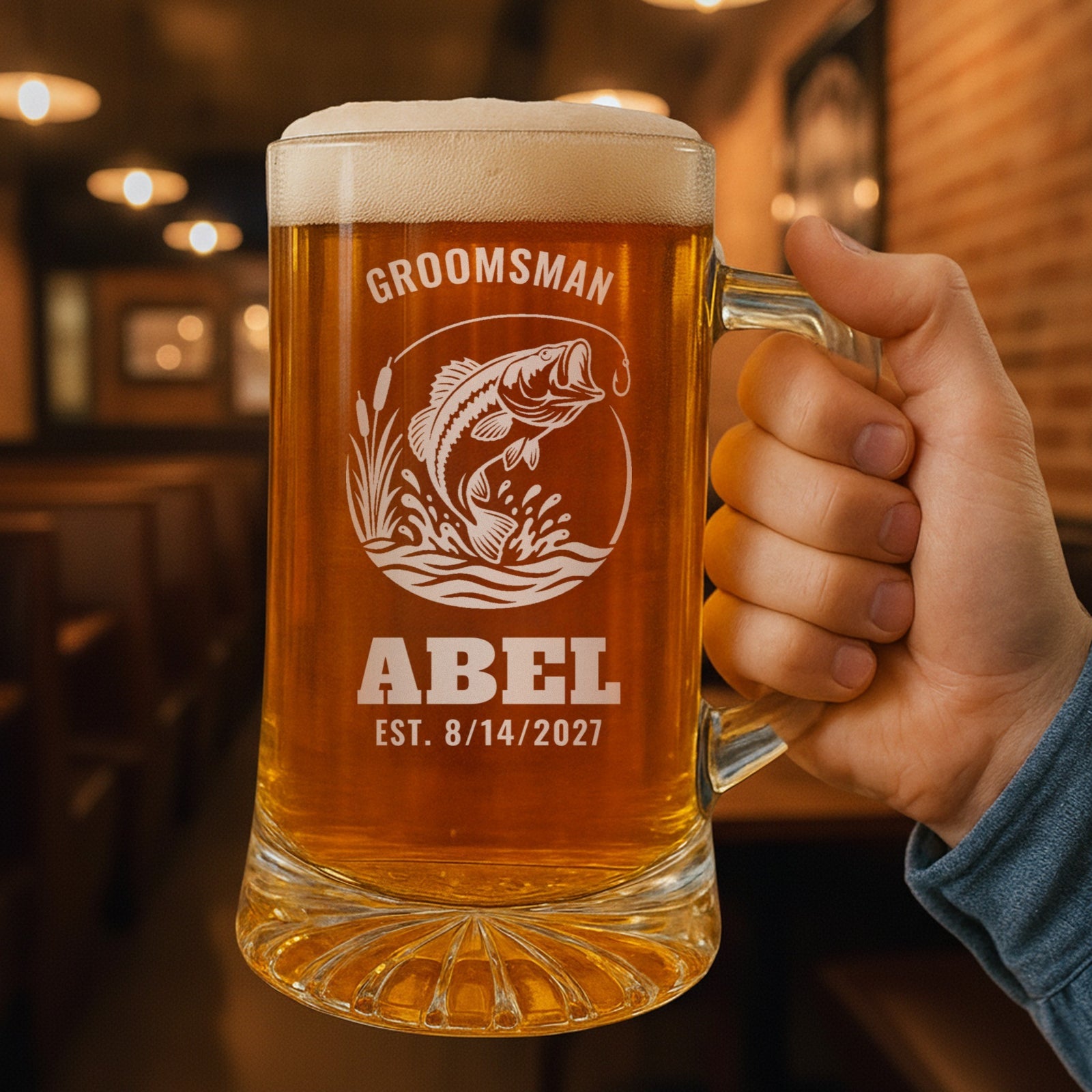 Hand holding the 25 oz personalized fishing beer stein in a pub, engraved with a leaping largemouth bass: Groomsman, Abel, Est. 8/14/2027