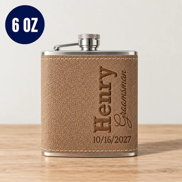 Tan leather flask with stainless steel cap, showing sample engraving of "Henry Groomsman" and date "10/16/2027", 6 oz capacity