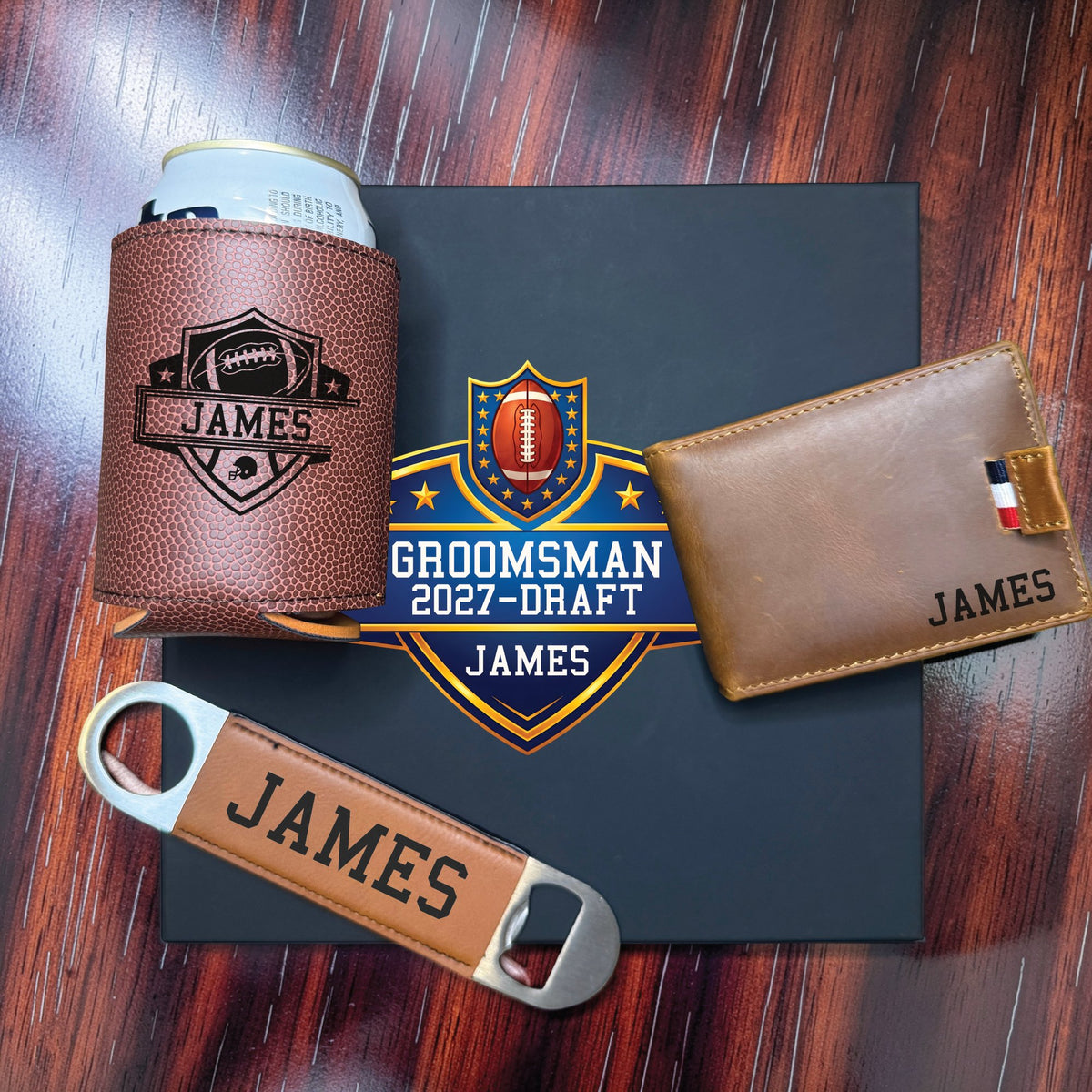 Personalized groomsmen draft gift set laid out on dark wood with the full colour football draft shield showing the wedding role, draft year and the name James.