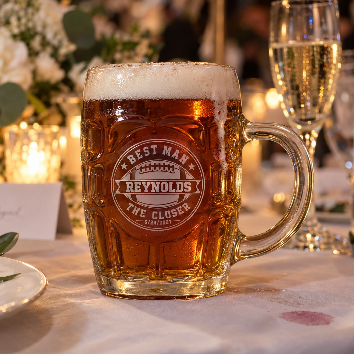 Engraved football beer stein for the best man on a reception table, personalized with Best Man, Reynolds, The Closer and the 6/24/2027 wedding date