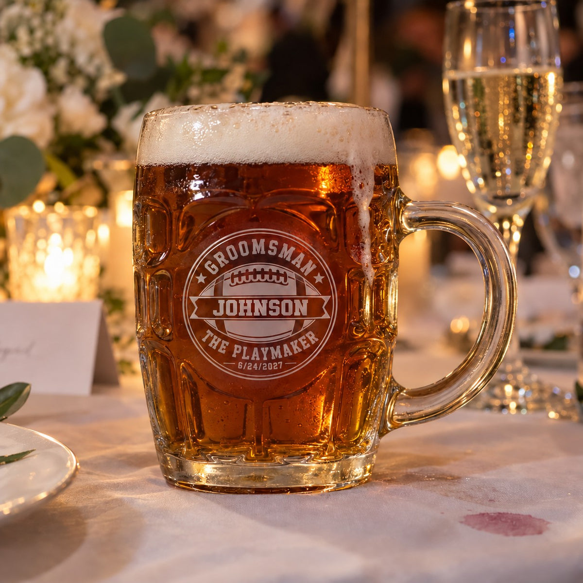 Football groomsman personalized beer stein filled with amber ale at a wedding reception, engraved Groomsman, Johnson, The Playmaker and 6/24/2027