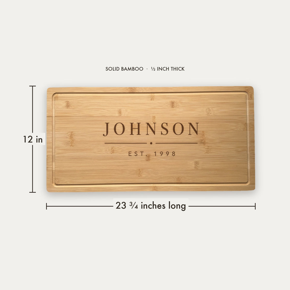 Size guide for the personalized last name cutting board, 23 and three quarter inches long by 12 inches wide in half inch thick solid bamboo.
