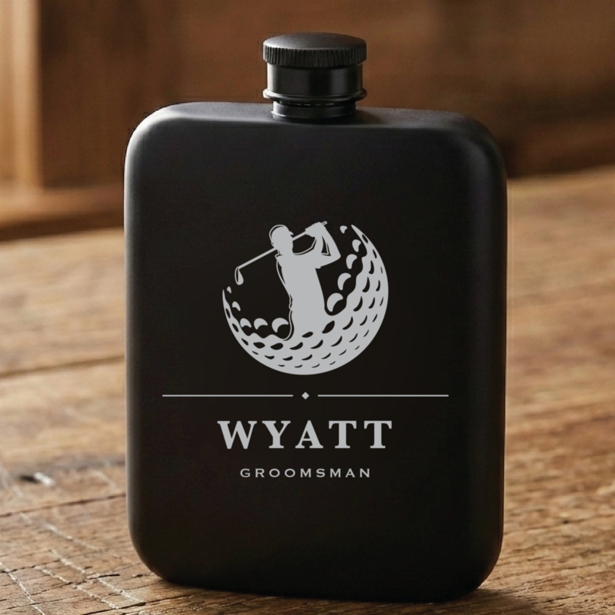 Matte black golf groomsmen flask laser engraved with a golfer mid swing inside a golf ball, the name Wyatt and Groomsman.