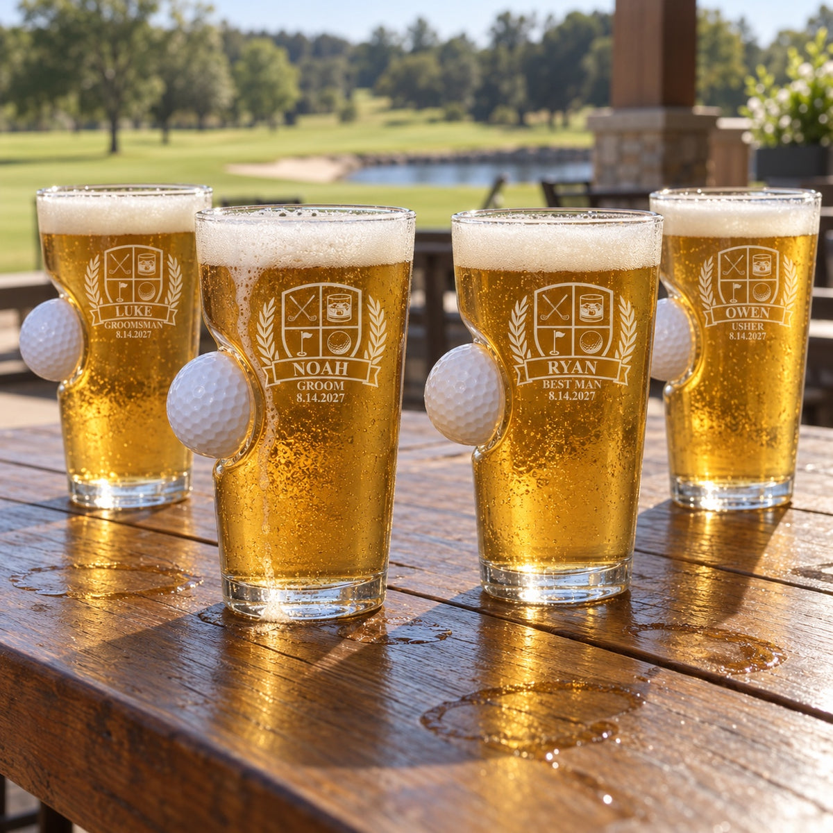 Four golf ball pint glasses for the wedding party on a clubhouse patio, engraved NOAH Groom, RYAN Best Man, LUKE Groomsman and OWEN Usher.