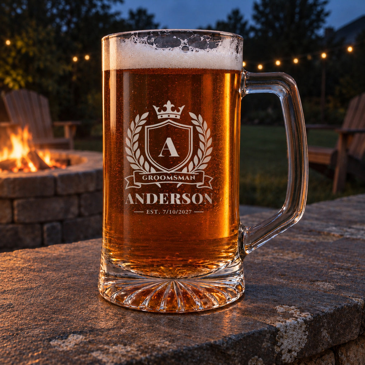 Personalized groomsman crest beer stein on a stone wall by a backyard fire pit at dusk, engraved with the initial A, Groomsman, Anderson and Est. 7/10/2027