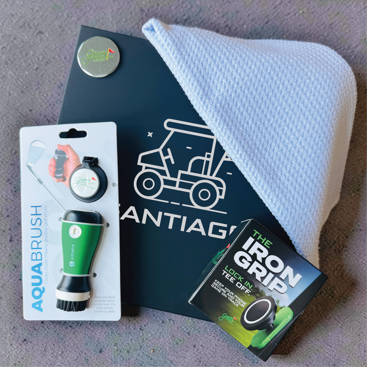 Groomsman golf gift box featuring a name-engraved keepsake box, club cleaner, waffle microfiber towel, ball marker and magnetic phone mount.