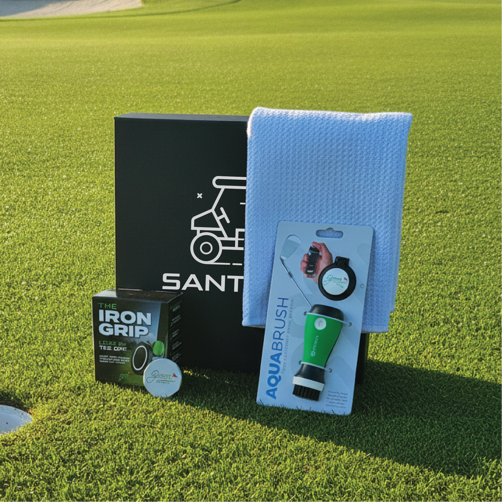 Engraved groomsman golf gift box shown with its magnetic phone mount, club cleaner, towel and ball marker.