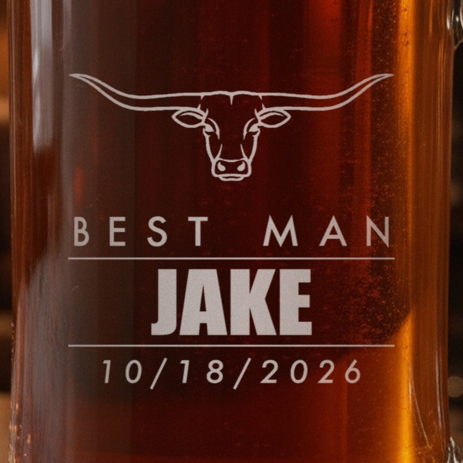 Close-up of the frosted laser engraving on the groomsmen beer stein: a longhorn steer, Best Man, Jake in bold and the date 10/18/2026